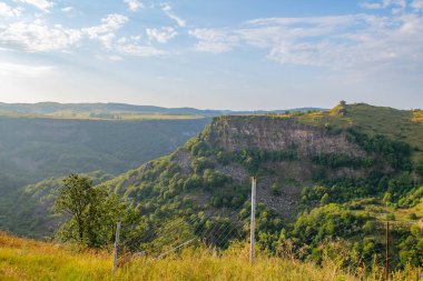 Gökyüzü mavi ve Gürcistan 'daki kanyonda bulutlar var.