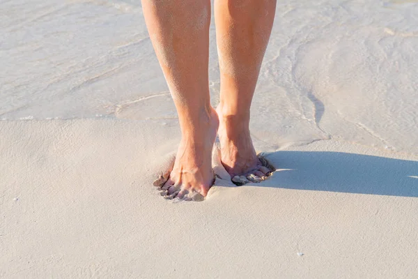 Feet on wet sandy beach in summer morning — Stock Photo, Image