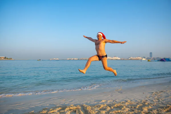 En un sombrero de Año Nuevo, un hombre en traje de baño saltando — Foto de Stock