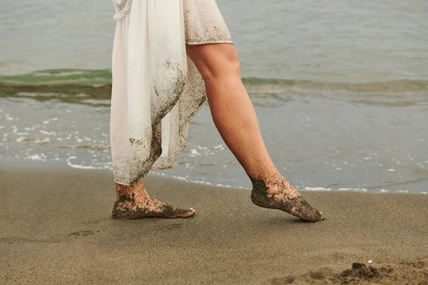 Womens leg on the beach in the sand — Stockfoto
