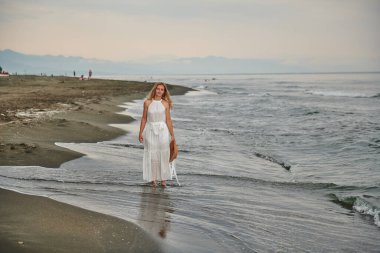 Sahilde beyaz elbiseli üzgün bir kız. Yüksek kalite fotoğraf