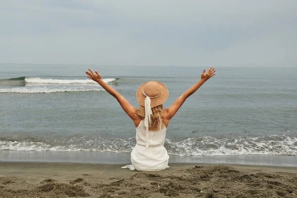站在海边的姑娘举起手 向远方望去 高质量的照片 — 图库照片