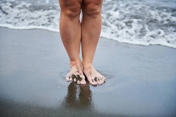 Auf Schwarzem Sand Stehen Zwei Frauenfüße Hochwertiges Foto — Stockfoto