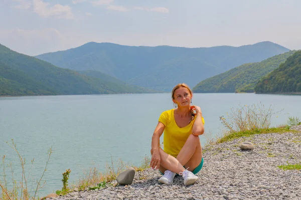 a woman sits on the shore of the Zhinvali reservoir. High quality photo