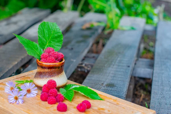 Delicious raspberry flowers and berries lie on a plank. High quality photo