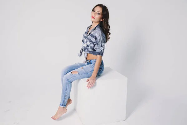 Flicka Rutig Skjorta Och Jeans Sitter Vit Kub Vit Bakgrund — Stockfoto