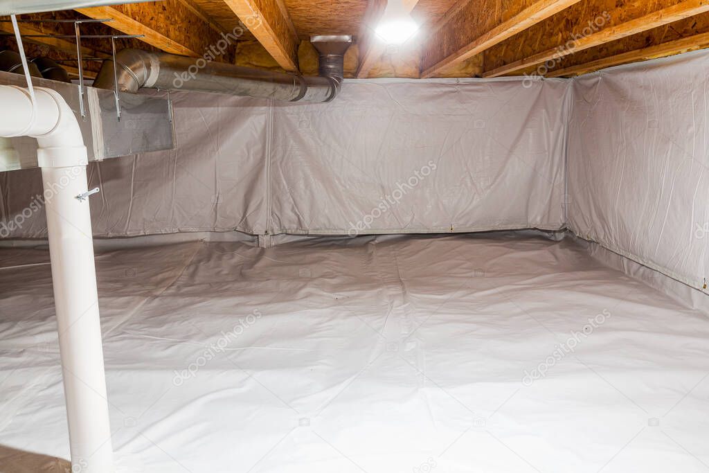 Crawl space fully encapsulated with thermoregulatory blankets and dimple board. Radon mitigation system pipes visible. Basement location for energy saving home improvement