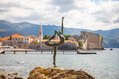 Budva, Karadağ - 18 Eylül 2021: Karadağ 'ın eski Budva kentinin arka planında bir dansçının heykeli