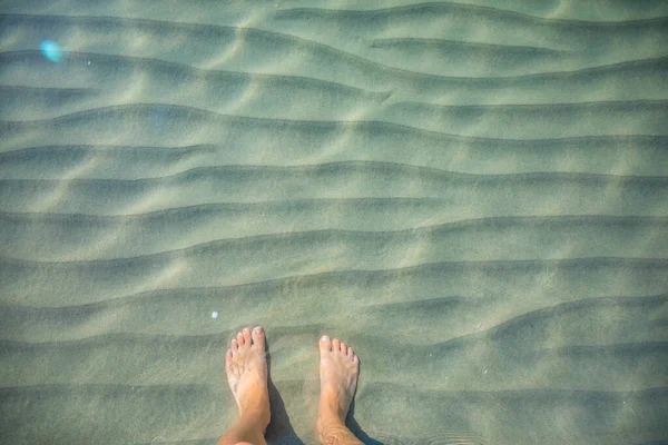 Top view of female feet under clear water. — Stock Photo, Image