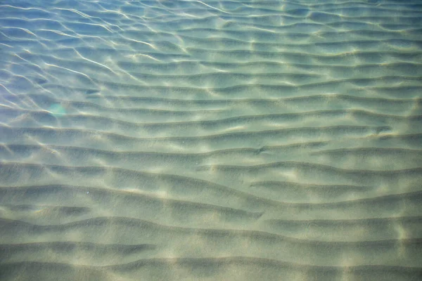 砂の海の底の表面に波紋,澄んだ穏やかな青い海の水,水の中の魚,自然のテクスチャ — ストック写真
