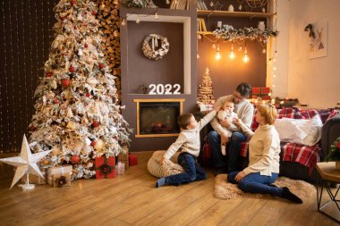 Modern dekore edilmiş evde, Noel ağacına yakın çok nesilli aile, Mutlu yıllar 2022