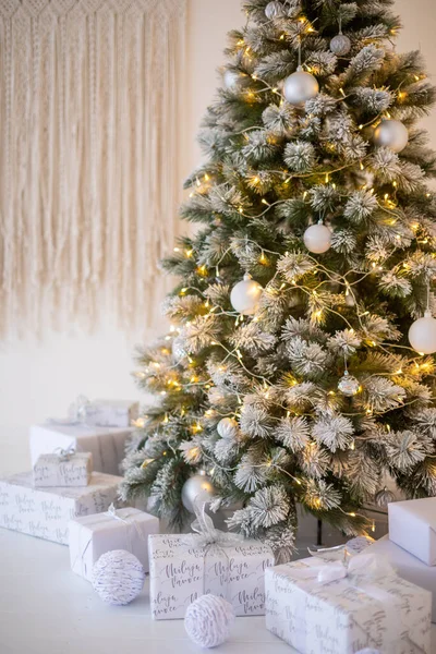 Beyaz karlı Noel ağacı hediyelerle evin içini süslüyor, yeni yıl. 