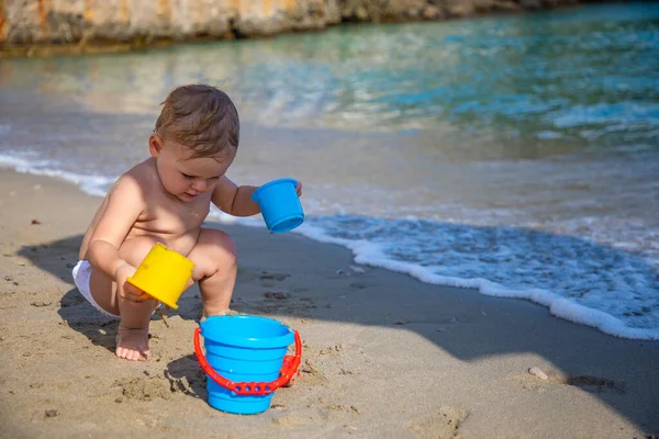 Niña jugando con arena en la playa. Disfrutando de unas vacaciones encantadoras . — Foto de Stock