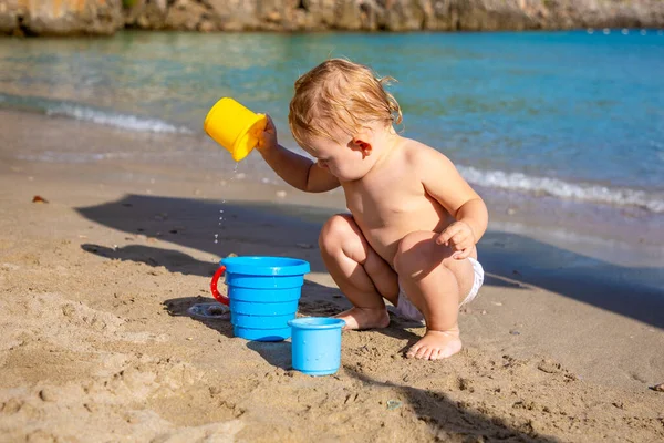 Sahilde kumla oynayan küçük bir kız. Güzel bir tatil zevk.