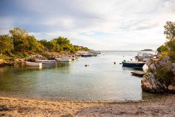 Рогозница, Хорватия - 12 октября 2021 года: район Лозица города Рогозница с песчаным пляжем, белой архитектурой и рыбацкими лодками на закате, Хорватия. — стоковое фото