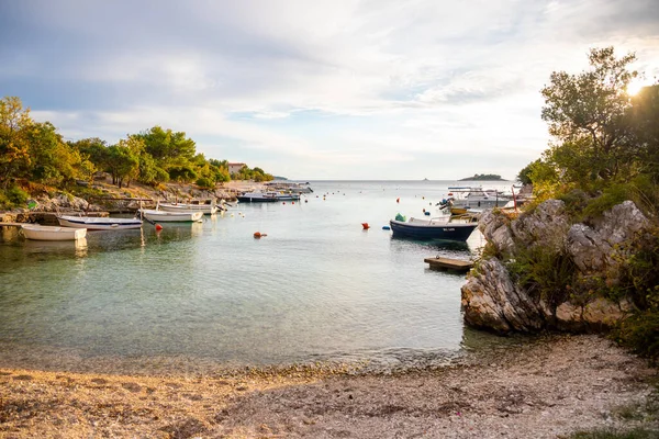 Рогозница, Хорватия - 12 октября 2021 года: район Лозица города Рогозница с песчаным пляжем, белой архитектурой и рыбацкими лодками на закате, Хорватия. — стоковое фото