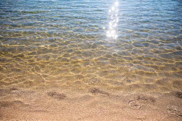 Κυματισμοί στην επιφάνεια της άμμου βυθού, διαυγή και ήρεμα νερά της θάλασσας, ψάρια στο νερό, φυσική υφή — Φωτογραφία Αρχείου