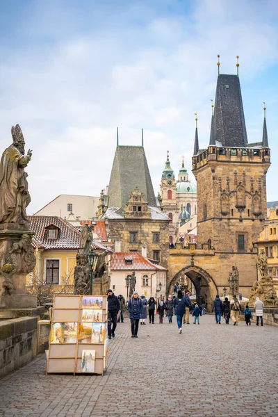 Prague, Czech Republic - Desember 26, 2021: Tourists out on the 15th century Charles Bridge in the snow in the morning — стоковое фото