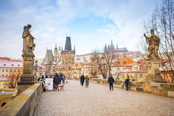 Прага, Чешская Республика - 26 декабря 2021: Туристы на Карлов мост 15-го века в снегу утром — стоковое фото
