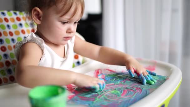 Menina bonito pintura com os dedos em casa. Jogos criativos para crianças. Fique em casa entretenimento — Vídeo de Stock