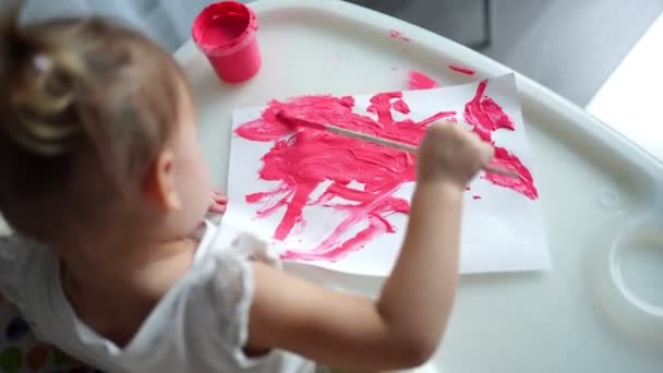 Menina bonito pintura com pincéis em casa. Jogos criativos para crianças. Fique em casa entretenimento — Vídeo de Stock