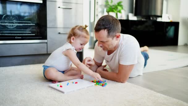 Мила дівчинка грає з грибною мозаїкою для нігтів. Батько і дитина грають разом концепцію. Хобі та дозвілля . — стокове відео
