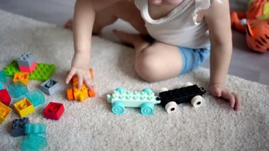 Beyaz bir çocuk evdeki inşaatçıda küçük bir kız oynuyor. Çocuklar için eğitici oyuncaklar.