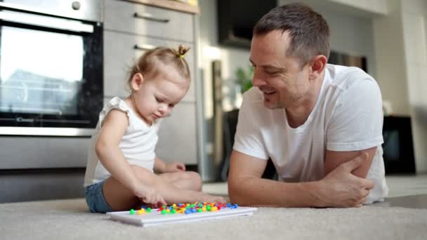 Cute little girl playing with mushroom nail mosaic. Father and baby playing together concept. Hobby and leisure time. — Stock Video