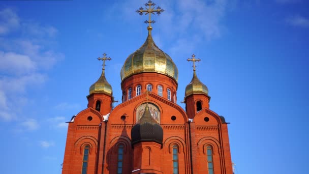Kemerovo, Rusia - 26 de febrero de 2022: Catedral de ladrillo Iglesia ortodoxa con cruces bajo un cielo azul en la ciudad de Kemerovo en Siberia, Rusia — Vídeos de Stock