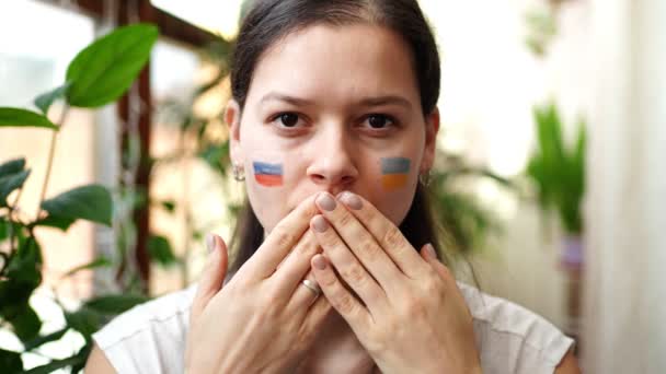 Jeune fille russo-ukrainienne avec le drapeau de l'Ukraine et la Russie sur son visage dit ARRÊTER LA GUERRE. Le concept de participation du peuple ukrainien à la guerre contre la Russie. Pas concept de guerre. — Video