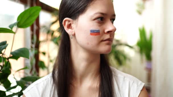 Portrait de jeune fille russo-ukrainienne avec le drapeau de l'Ukraine et de la Russie sur son visage. Le concept de participation du peuple ukrainien à la guerre contre la Russie. Pas concept de guerre — Video