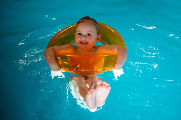 Niña en la piscina casa privada en un círculo de natación disfruta de salpicaduras —  Fotos de Stock