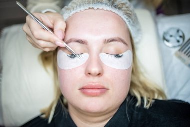 Güzellik salonunda kirpik uzatma prosedürü. Kırbaçlar yakın. Spa kirpiklerini kavra. 