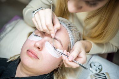 Güzellik salonunda kirpik uzatma prosedürü. Kırbaçlar yakın. Spa kirpiklerini kavra. 