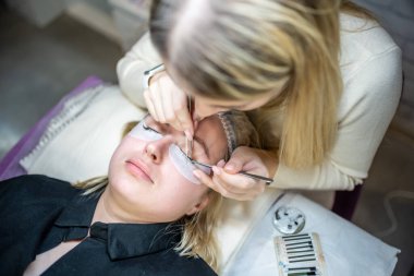 Güzellik salonunda kirpik uzatma prosedürü. Kırbaçlar yakın. Spa kirpiklerini kavra. 