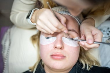 Güzellik salonunda kirpik uzatma prosedürü. Kırbaçlar yakın. Spa kirpiklerini kavra. 