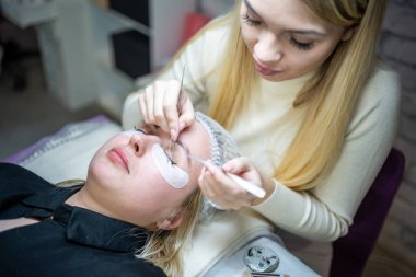 Güzellik salonunda kirpik uzatma prosedürü. Kırbaçlar yakın. Spa kirpiklerini kavra. 
