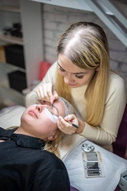 Güzellik salonunda kirpik uzatma prosedürü. Kırbaçlar yakın. Spa kirpiklerini kavra. 