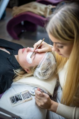 Güzellik salonunda kirpik uzatma prosedürü. Kırbaçlar yakın. Spa kirpiklerini kavra. 