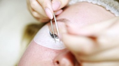 Güzellik salonunda kirpik uzatma prosedürü. Kırbaçlar yakın. Spa kirpiklerini kavra. 