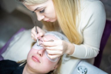 Güzellik salonunda kirpik uzatma prosedürü. Kırbaçlar yakın. Spa kirpiklerini kavra. 