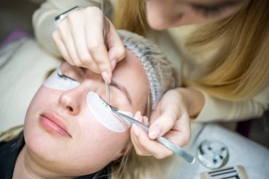 Güzellik salonunda kirpik uzatma prosedürü. Kırbaçlar yakın. Spa kirpiklerini kavra. 