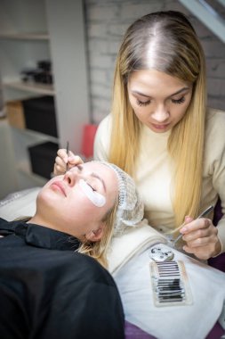 Güzellik salonunda kirpik uzatma prosedürü. Kırbaçlar yakın. Spa kirpiklerini kavra. 
