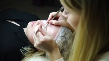 Güzellik salonunda kirpik uzatma prosedürü. Kırbaçlar yakın. Spa kirpiklerini kavra. 