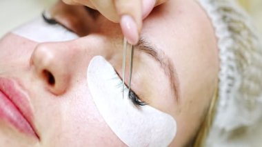 Güzellik salonunda kirpik uzatma prosedürü. Kırbaçlar yakın. Spa kirpiklerini kavra. 