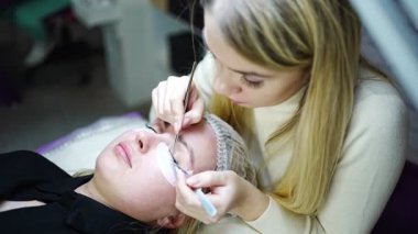 Güzellik salonunda kirpik uzatma prosedürü. Kırbaçlar yakın. Spa kirpiklerini kavra. 