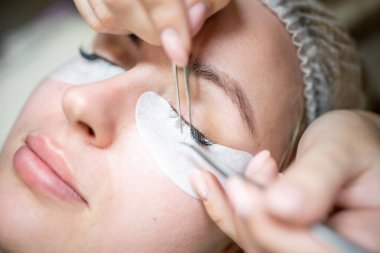 Güzellik salonunda kirpik uzatma prosedürü. Kırbaçlar yakın. Spa kirpiklerini kavra. 