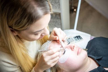 Güzellik salonunda kirpik uzatma prosedürü. Kırbaçlar yakın. Spa kirpiklerini kavra. 