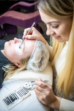 Güzellik salonunda kirpik uzatma prosedürü. Kırbaçlar yakın. Spa kirpiklerini kavra. 