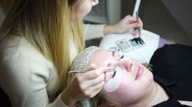 Güzellik salonunda kirpik uzatma prosedürü. Kırbaçlar yakın. Spa kirpiklerini kavra. 